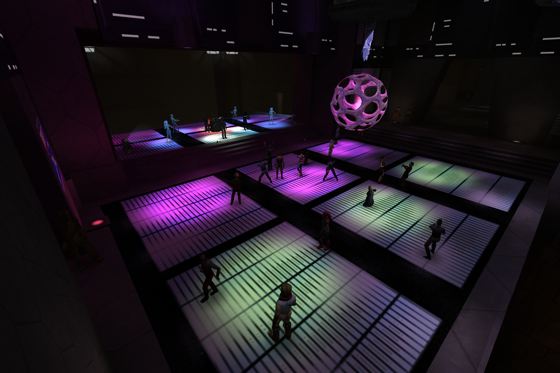 The same hall transformed into a nightclub with glowing pink and green dance floors, a crowd dancing, a band on the raised stage and a lit sphere hanging overhead.